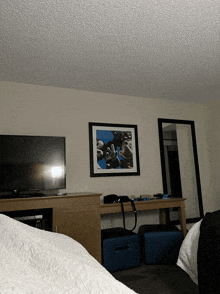 a hotel room with a picture of mickey mouse on the wall above a flat screen tv