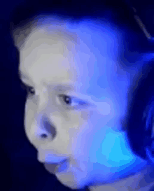 a close up of a child wearing headphones and looking at a computer screen .