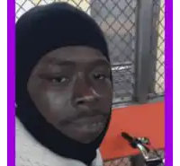 a man wearing a black balaclava is looking at the camera