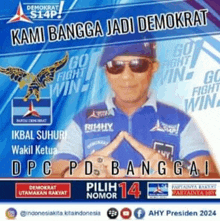 a man wearing sunglasses and a blue shirt with the words kami bangsa jadi demokrat on it