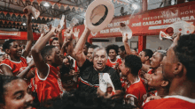 a man holds a hat in the air in front of a banner that says presidente de honra