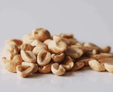 a pile of peanuts with their shells removed on a white surface