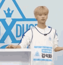 a young man stands in front of a podium with a crown on it and a name tag that says ' i '