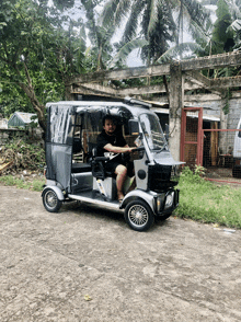 a man wearing a nike shirt is driving a rickshaw