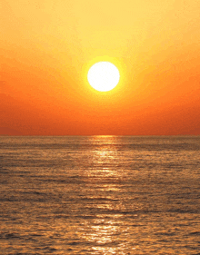 the sun is setting over the ocean and the sun is reflected in the water