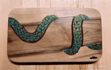 a painting of a snake on a wooden board