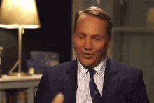 a man in a suit and tie is making a face with his eyes closed