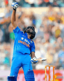 a cricket player wearing a blue shirt that says ' india ' on it