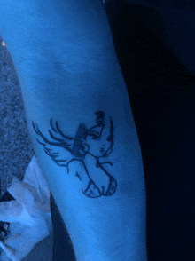 a blue tattoo of a woman 's face with wings on her arm