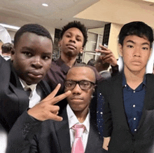 a group of young men wearing suits and ties pose for a photo