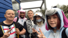 a group of young people dressed up in animal costumes including a zebra and a penguin