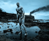 a man with white paint on his body stands in the water