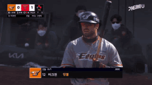 a baseball player for the eagles holds a bat in his hand