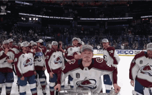 a group of hockey players are posing with a trophy in front of a sign that says congratulations on it