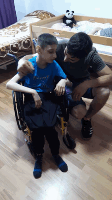 a boy in a wheelchair wearing a shirt that says ' superman '