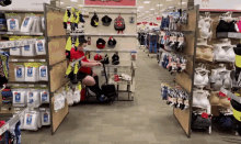 a man in a red shirt is pushing a shopping cart in a store with a sign that says underwear