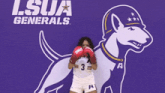 a woman wearing boxing gloves in front of a purple lsua generals logo