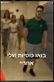 a man in a green shirt is walking down a hallway with a group of people