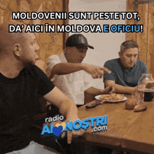 a group of men are sitting at a table with a sign that says radio a nostri