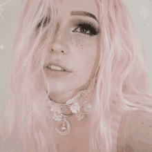 a woman with pink hair and freckles is wearing a choker with a crescent moon pendant