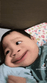 a baby laying on a bed with a tiktok watermark on the bottom right