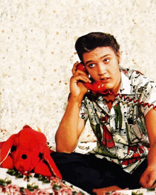 elvis presley is talking on a red phone