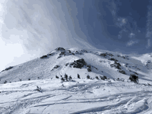 a snowy mountain with a blue sky and clouds