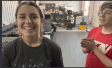 a girl wearing a black shirt with the word evo on it smiles next to a boy wearing a red shirt