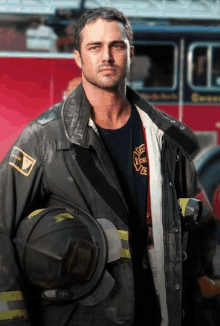 a man in a firefighter 's uniform holds a helmet