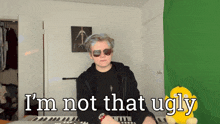 a man wearing sunglasses says i 'm not that ugly in front of a keyboard