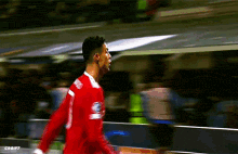 a blurry picture of a soccer player wearing a red jersey with the word e on it