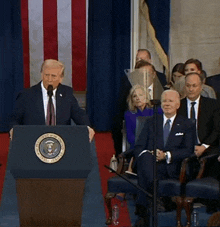 a man stands behind a podium with the seal of the president of the united states on it