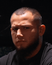 a close up of a man 's face with a black shirt on