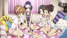 a group of anime girls are sitting on a blanket looking at a plate of cupcakes