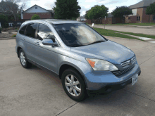 a silver honda crv parked in a driveway with a texas license plate