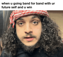 a man with curly hair and a beard is wearing a red and white scarf around his head