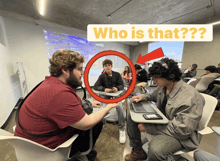 a group of people are sitting in a classroom with a sign that says who is that