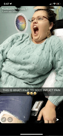 a woman in a blue sweater is laying in a hospital bed with her mouth wide open