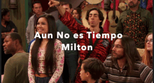 a group of people standing in a crowd with the words aun no es tiempo milton