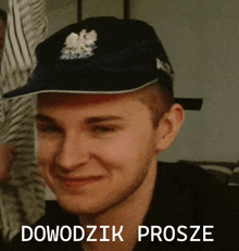 a man wearing a hat that says ' dowodzk prosze ' on the bottom