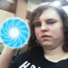 a young woman is holding a blue ball in her hand and making a funny face .