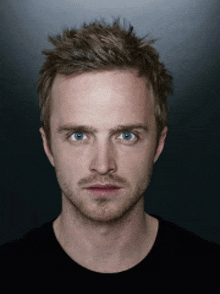 a close up of a man 's face with blue eyes and a beard