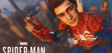 a man in a spider-man suit is giving a peace sign .