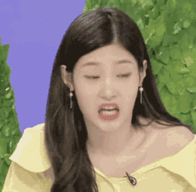 a woman wearing a yellow off the shoulder top making a funny face