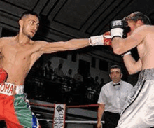 two men are boxing in a ring and one of them has a belt that says ' ohar ' on it