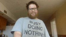 a man with a beard wears a busy doing nothing shirt