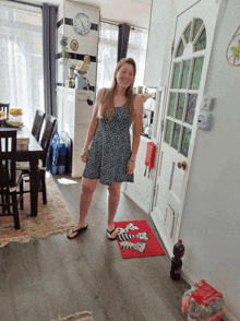 a woman in a black and white dress is standing in a room