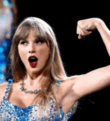 a woman in a blue and silver dress is flexing her muscles