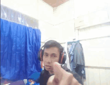 a man wearing headphones is giving a middle finger .