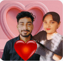 a man and a woman are posing for a picture with a heart in the background and the word happy on the bottom right